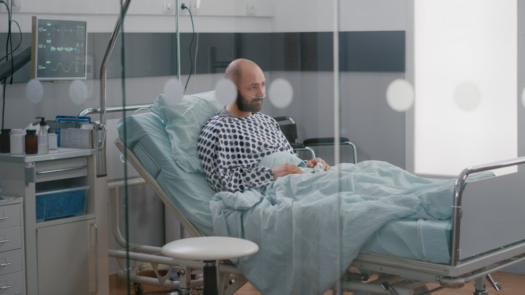 young bold man in his bed at hospital